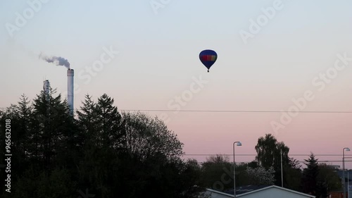 Hot air ballon in city sky near sunset