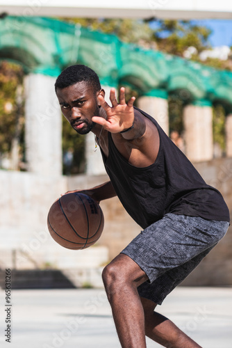 Basketball street player dribbling with ball on the court - Streetball, training and activity concept