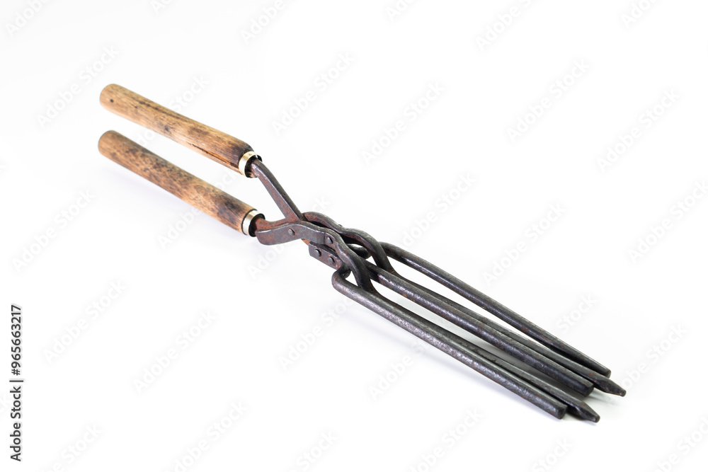 Ancient barber pair of tongs on white background. Vintage curling iron. beauty concept Ancient barber pair of tongs on white background. Vintage curling iron. beauty concept