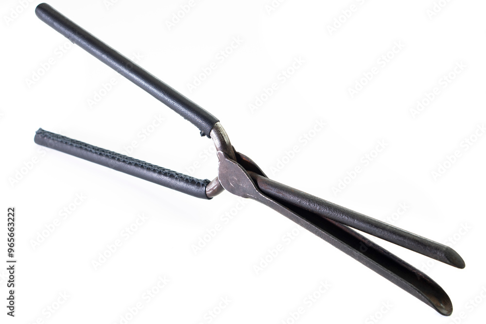 Ancient barber pair of tongs on white background. Vintage curling iron. beauty concept Ancient barber pair of tongs on white background. Vintage curling iron. beauty concept