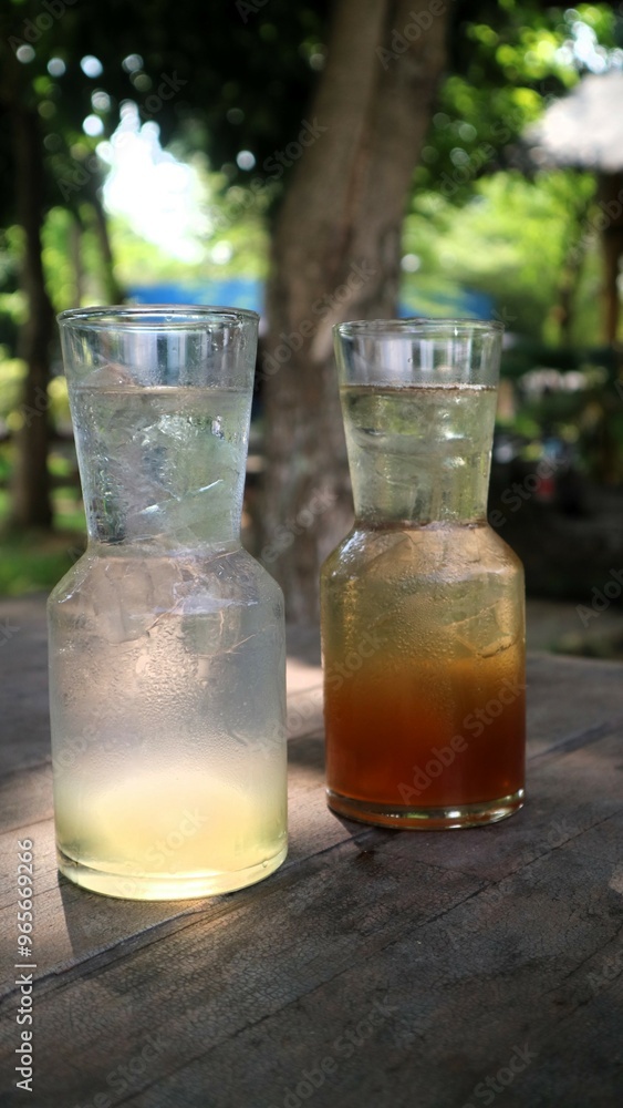 Side view iced tea and iced lime drink served with unique shaped glass, fresh cooled drink Side view iced tea and iced lime drink served with unique shaped glass, fresh cooled drink
