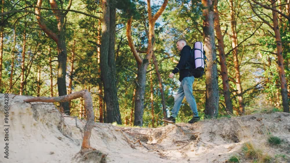 A Hiker Surrounded by the Beauty of a Peaceful and Serene Forest Walking Path Today. Hiking, young handsome male adventurer walking through the forest with a big backpack. A Hiker Surrounded by the Beauty of a Peaceful and Serene Forest Walking Path Today. Hiking, young handsome male adventurer walking through the forest with a big backpack.