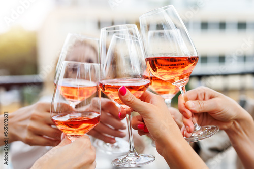 Fototapeta Close-up many female woman hands hold clinking rose wine glass celebrate toast party terrace warm sunset sun background