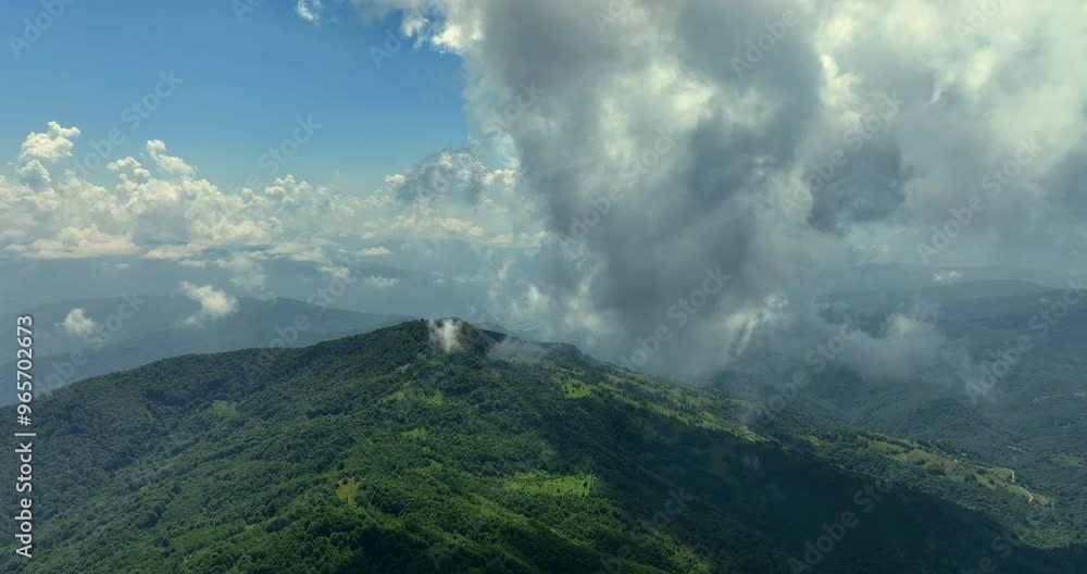 Flying trough white fluffy clouds above green mountain peaks. Beautiful summer sunny day on the high altitude with thick clouds and scenic landscape in background. Cinematic nature aerial video in 4K Flying trough white fluffy clouds above green mountain peaks. Beautiful summer sunny day on the high altitude with thick clouds and scenic landscape in background. Cinematic nature aerial video in 4K
