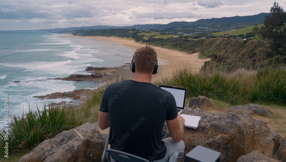 Fototapeta premium A man is sitting at his laptop on the beach
