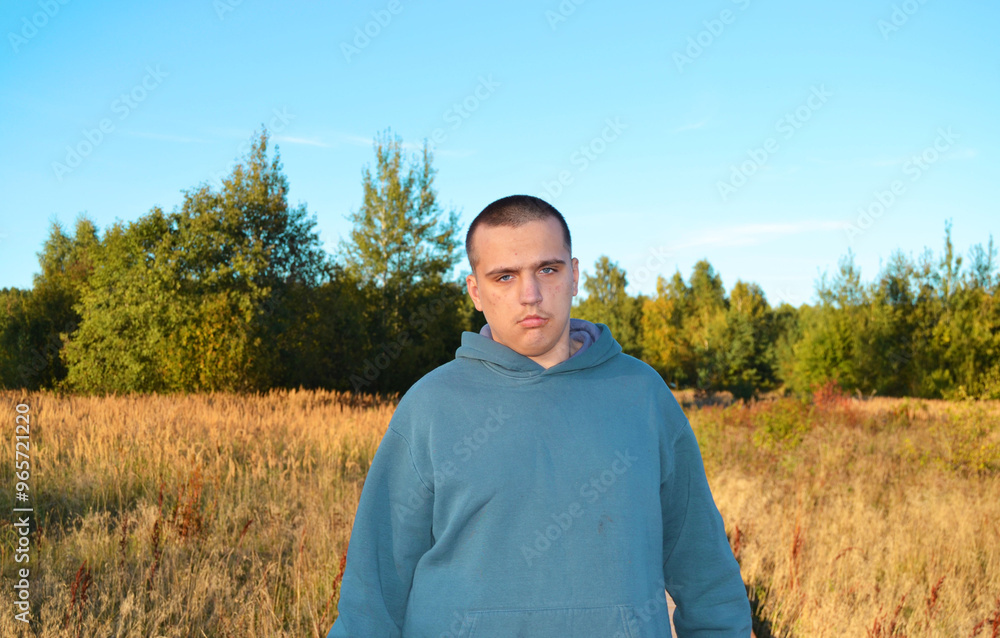 A young autistic guy on a walk in the autumn park A young autistic guy on a walk in the autumn park