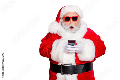 Portrait of impressed christmas father in hat using cell phone  device screaming omg wearing read about festive events eyeglasses eyewear belt isolated over red background photo