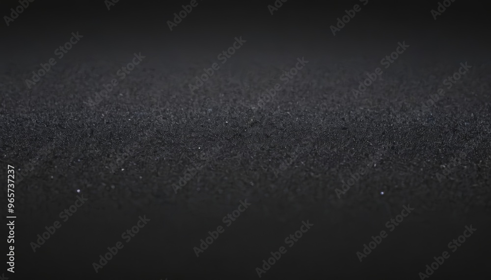 A close up of a black textured surface with a subtle gradient of gray. A close up of a black textured surface with a subtle gradient of gray.