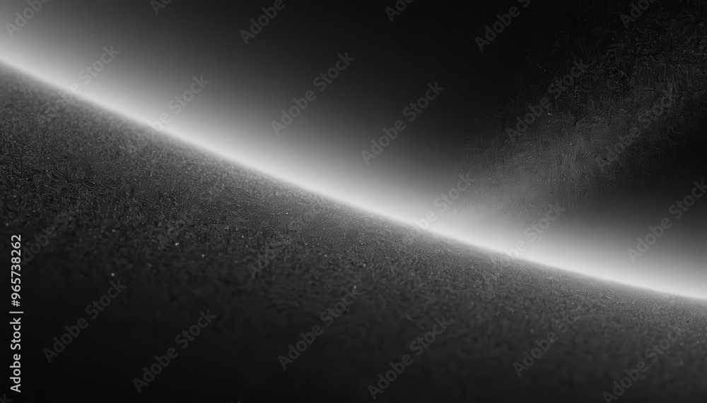 A black and white image of a curved surface with textured details and a white light glow in the background. A black and white image of a curved surface with textured details and a white light glow in the background.