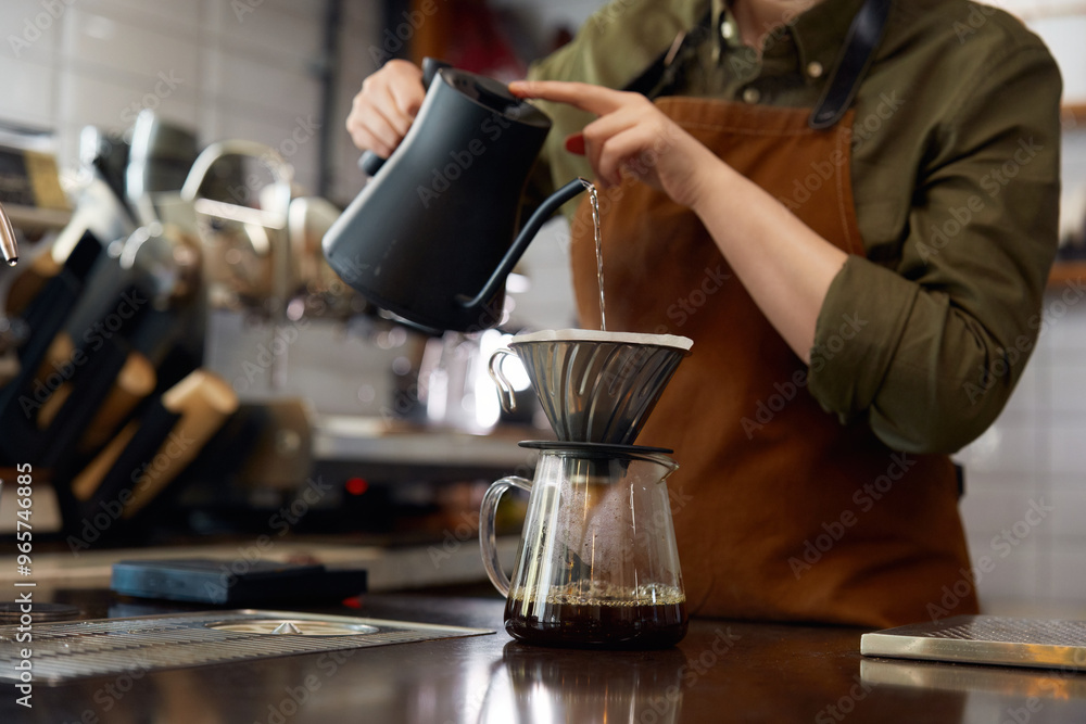 Cropped shot of barista hands pouring boiling water into filter coffee pot Cropped shot of barista hands pouring boiling water into filter coffee pot