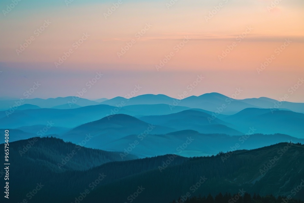 Layers of blue mountain ridges at sunrise. Serene landscape with pastel sky. Layers of blue mountain ridges at sunrise. Serene landscape with pastel sky.
