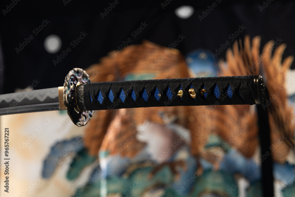Japanese katana samurai sword hang in air over Kimono blur background. Sharp blade of katana samurai sward is weapon of japanese warrior martial art Japanese katana samurai sword hang in air over Kimono blur background. Sharp blade of katana samurai sward is weapon of japanese warrior martial art