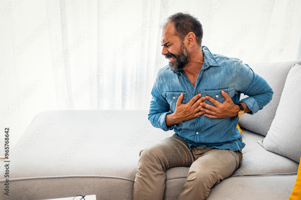 Middle-Aged Man Suffering Chest Pain on Sofa Middle-Aged Man Suffering Chest Pain on Sofa