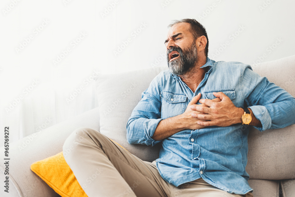 Middle-Aged Man Experiencing Chest Pain on Sofa Middle-Aged Man Experiencing Chest Pain on Sofa