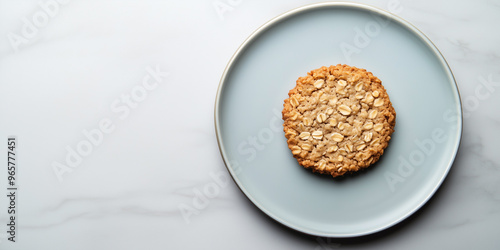 Single oatmeal cookie placed on a flat dessert plate