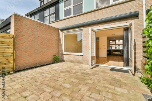 Modern home entrance with open door and brick wall