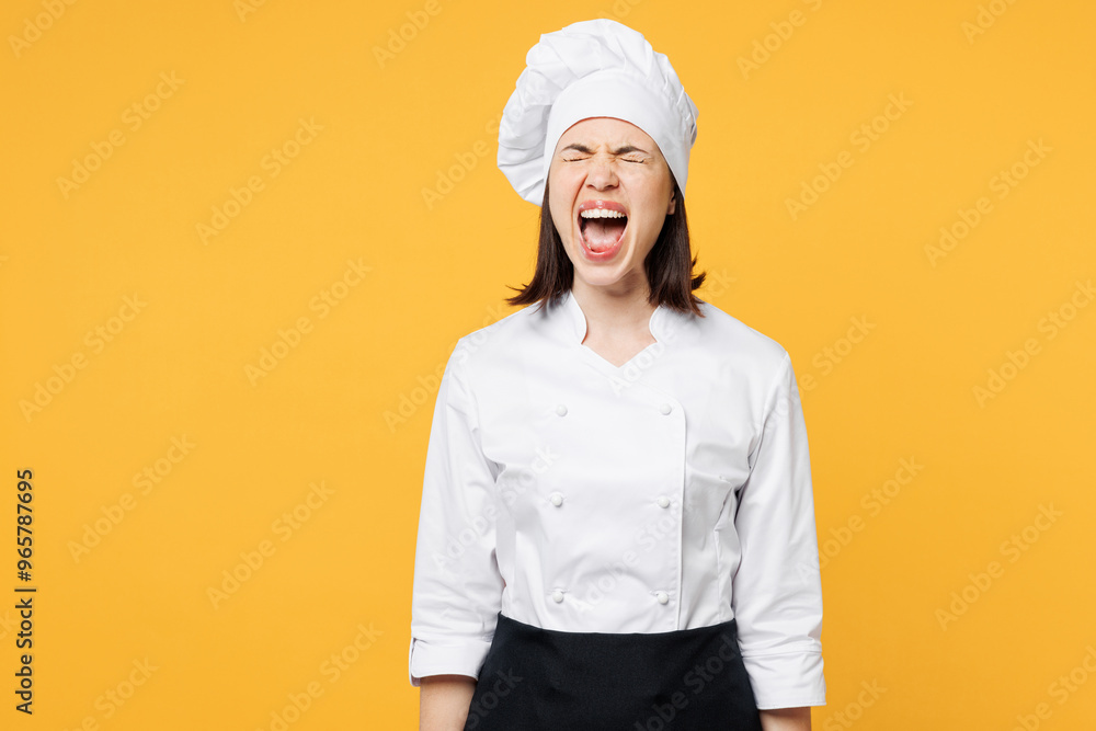 Young sad stressed irritated mad chef cook baker woman wear white shirt black apron uniform toque chefs hat swearing cry scream shout isolated on plain yellow background studio. Cooking food concept. Young sad stressed irritated mad chef cook baker woman wear white shirt black apron uniform toque chefs hat swearing cry scream shout isolated on plain yellow background studio. Cooking food concept.
