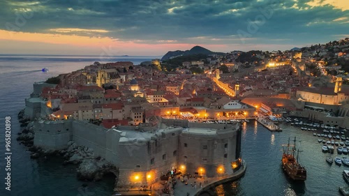 Wallpaper Mural Dubrovnik old town after sunset with city lights. Aerial shot of historic city of Dubrovnik in Croatia, UNESCO World Heritage site. Illuminated streets, buildings and marina with boats. 4K HDR shot  Torontodigital.ca