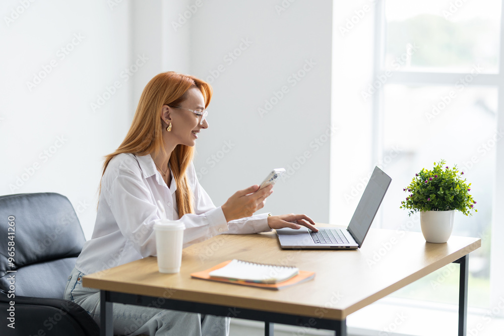 Beautiful woman iuses internet phone close up, female worker reads message and browses internet pages inside office Beautiful woman iuses internet phone close up, female worker reads message and browses internet pages inside office