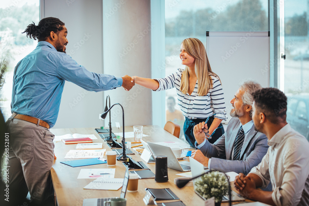 Diverse Team Celebrating Success with a Handshake in Office Diverse Team Celebrating Success with a Handshake in Office