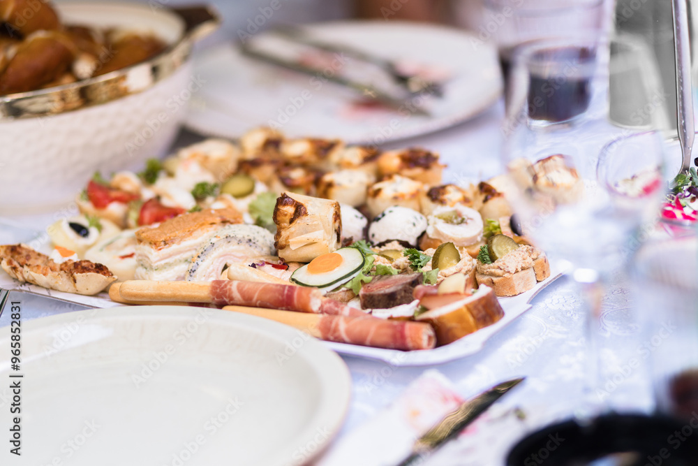 Assorted gourmet appetizers arranged elegantly on a platter during a festive gathering Assorted gourmet appetizers arranged elegantly on a platter during a festive gathering