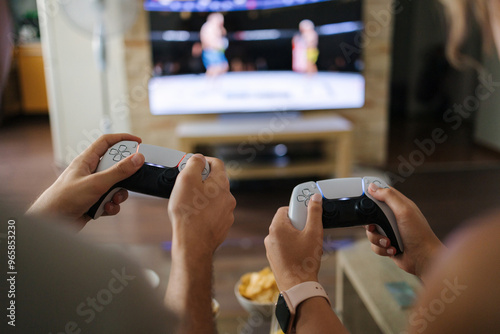 First person view of couple using joysticks to play video games on console