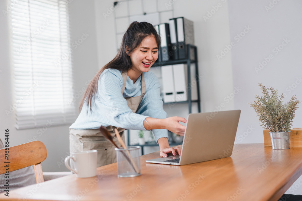A young woman in cozy home office smiles while working on her laptop, showcasing productive and cheerful atmosphere. A young woman in cozy home office smiles while working on her laptop, showcasing productive and cheerful atmosphere.