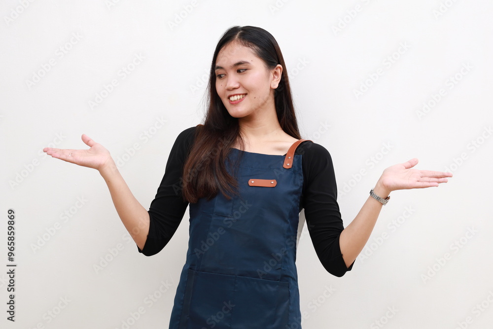Asian young woman wearing apron over white background smiling showing both hands open palms, presenting and advertising comparison and balance Asian young woman wearing apron over white background smiling showing both hands open palms, presenting and advertising comparison and balance