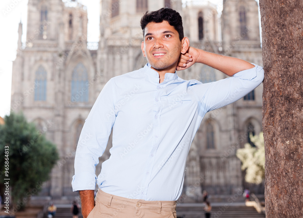 Fototapeta premium Smiling young guy on city street