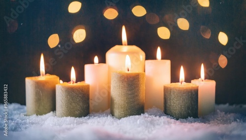 Many Burning Christmas candle and snow with beautiful colorful bokeh on background; winter season concept 