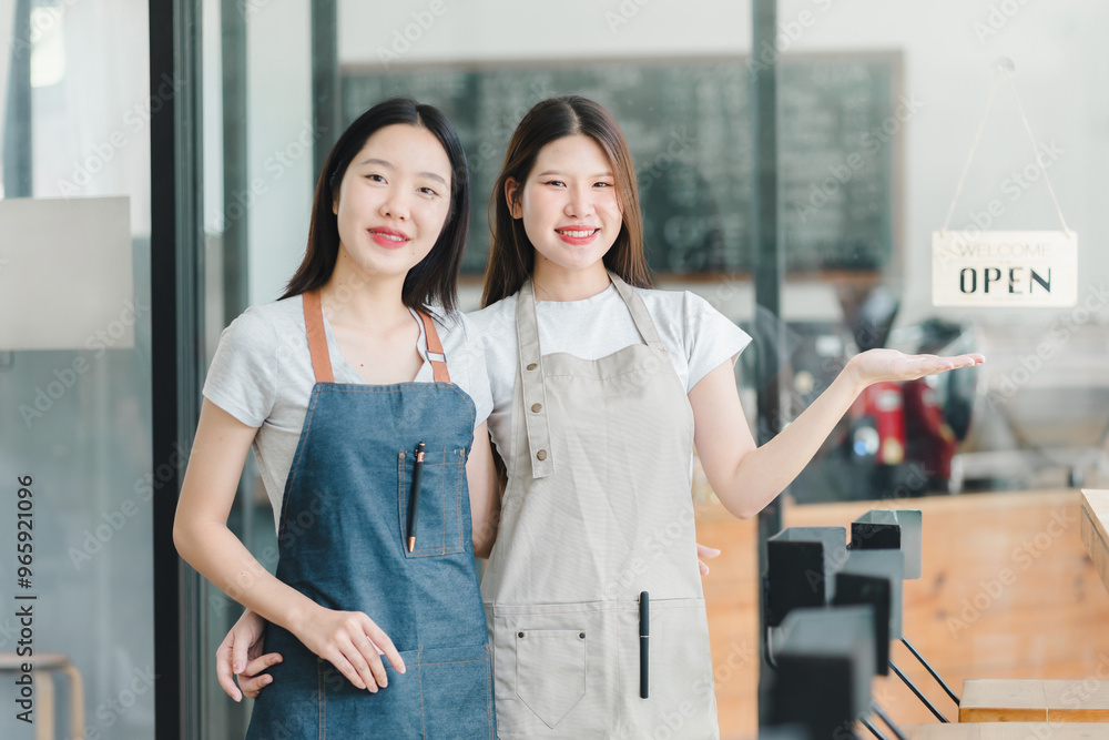 Fototapeta premium Welcoming baristas in aprons stand proudly by open sign.