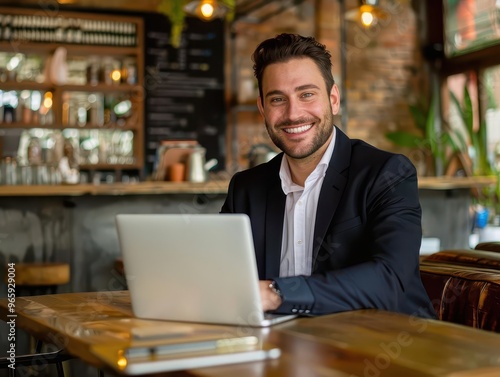 charismatic businessman working on a laptop in a trendy cafe setting his warm smile and engaging expression convey confidence and approachability in a modern professional context