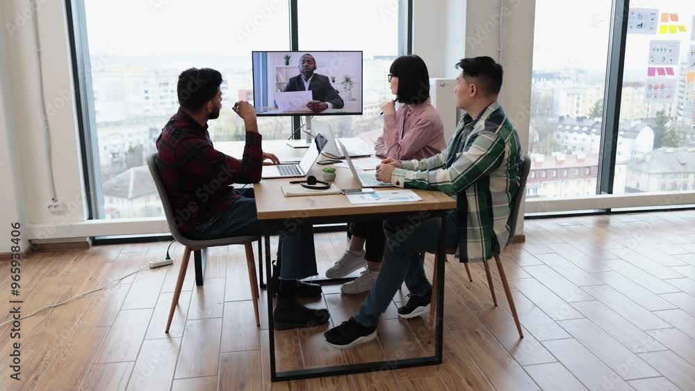 Business team engaged in video conference meeting discussing financial report. Team members focused on presentation from remote colleague displayed on screen. Concept of teamwork, remote communication Business team engaged in video conference meeting discussing financial report. Team members focused on presentation from remote colleague displayed on screen. Concept of teamwork, remote communication