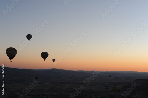 Beautiful view of hot air balloons floating in the air at sunrise with clear sky in Cappadocia, Turkey (Türkiye)