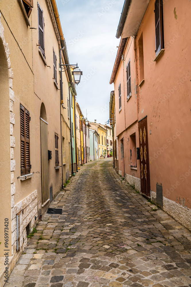 Fototapeta premium A view up the narrow main street in the hilltop fortress village of Sant Andrea di Suasa, Italy in summertime