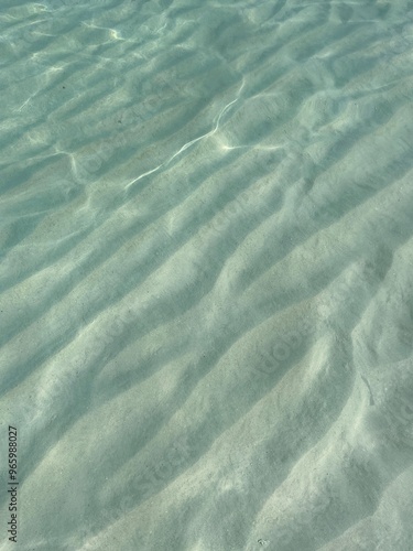 Clear water reflections on shallow sandy beach bottom, Maldives in a summer day