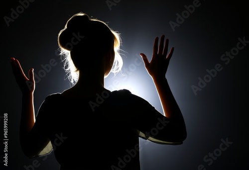 Backlit with Halo Effect Woman standing with hands raised backli photo