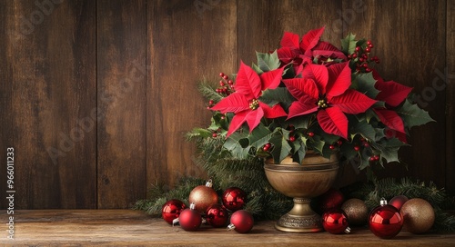 Festive holiday arrangement with red poinsettias and ornaments on a rustic wo...