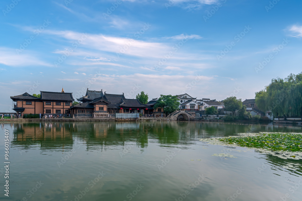 Fototapeta premium Serene Waterfront Scenery with Traditional Architecture and Clear Sky