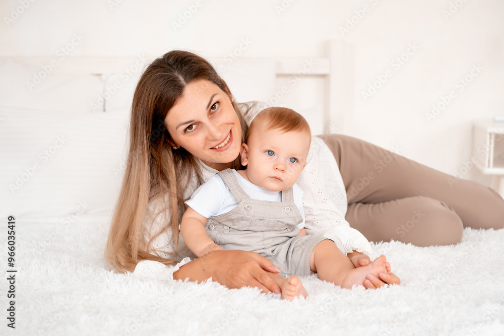 mom with baby, young mom gently hugs and kisses her baby son at home on the bed, maternal love and care, happy decree, mother and little baby boy mom with baby, young mom gently hugs and kisses her baby son at home on the bed, maternal love and care, happy decree, mother and little baby boy