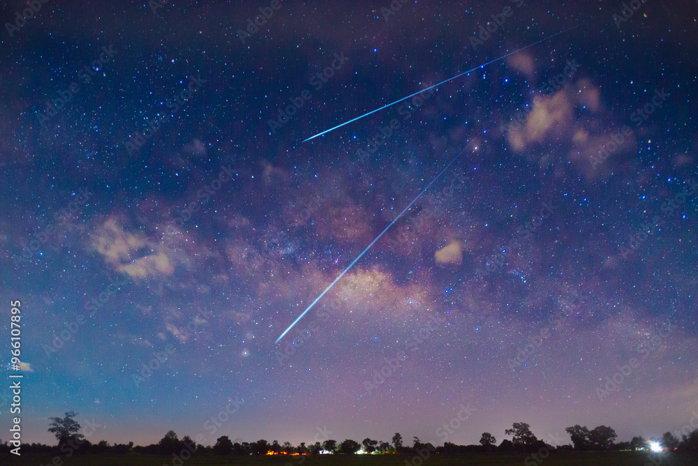 Naklejka premium meteorites fly in the night sky. Bright meteors glow in the atmosphere. Beautiful shooting stars.