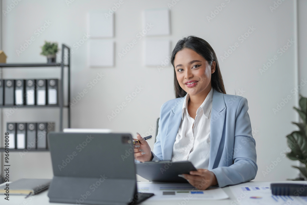 Young manager smiling while working on documents in her office Young manager smiling while working on documents in her office