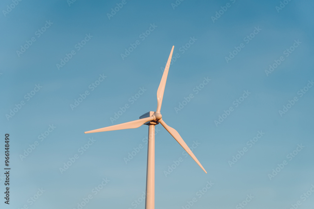 toy white wind turbine outdoors at sunset in summer, blue sky in background, alternative electricity source concept, copy space toy white wind turbine outdoors at sunset in summer, blue sky in background, alternative electricity source concept, copy space