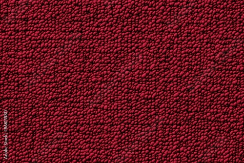 Texture of a cotton chenille red surface with a bumpy, granular appearance, resembling a fabric or material with small raised dots.
