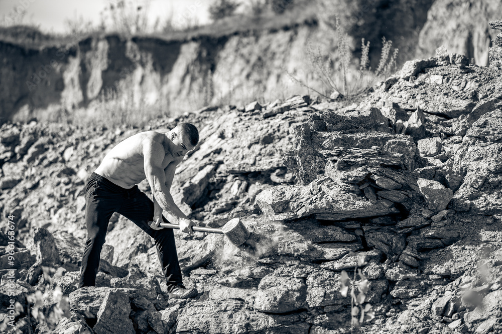 Man chiseling stone in a rocky quarry under bright sunlight. A man is chiseling stone in a rocky quarry with determination during sunny weather. Man chiseling stone in a rocky quarry under bright sunlight. A man is chiseling stone in a rocky quarry with determination during sunny weather.