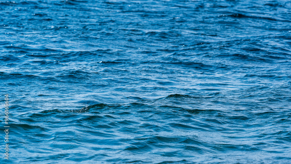 Small waves on blue water with reflections of sunlight Small waves on blue water with reflections of sunlight