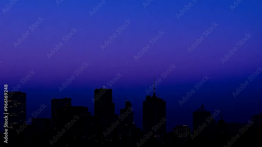 Dark silhouettes of skyscrapers and office buildings composing the skyline of a modern downtown at sunset, with a bright colorful sky Dark silhouettes of skyscrapers and office buildings composing the skyline of a modern downtown at sunset, with a bright colorful sky