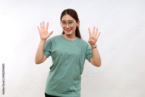 Smiling happy good-looking asian girl giving advice, showing nine fingers as explain rules, make point, standing white background
