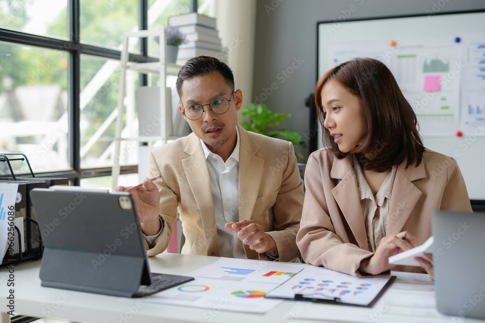 Businesspeople having meeting analyzing financial documents using digital tablet Businesspeople having meeting analyzing financial documents using digital tablet