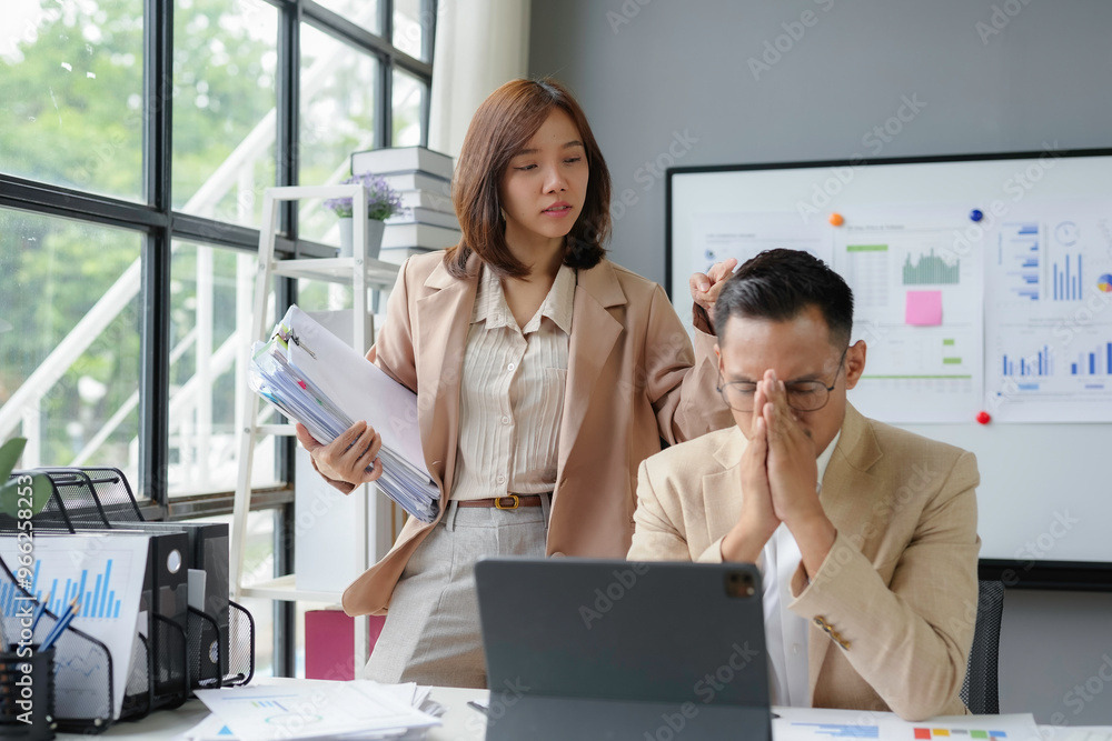 Businesswoman giving more work to stressed businessman in office Businesswoman giving more work to stressed businessman in office